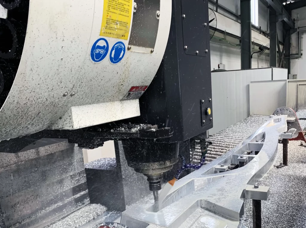 Close-up of a CNC milling machine cutting an aluminum workpiece, with metal chips flying during the machining process in a factory setting