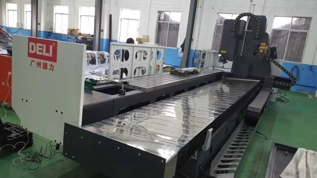 Guangzhou Deli’s large gantry CNC machining center in a factory, showcasing its robust structure and reflective worktable for industrial metal processing