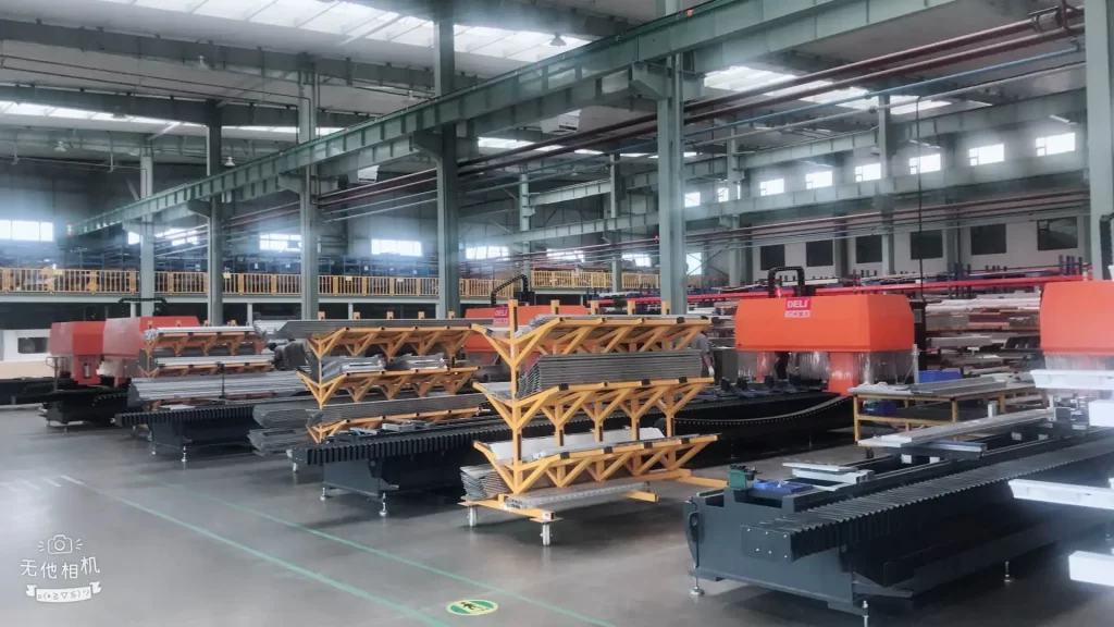 Large-scale factory workshop showcasing an organized layout of CNC metal processing equipment, specialized in aluminum/steel profile manufacturing. Multiple industrial machines (e.g., precision cutting systems) are arranged for efficient workflow, highlighting automated production capacity, high-precision machining capabilities, and a professional manufacturing environment for custom metal components.