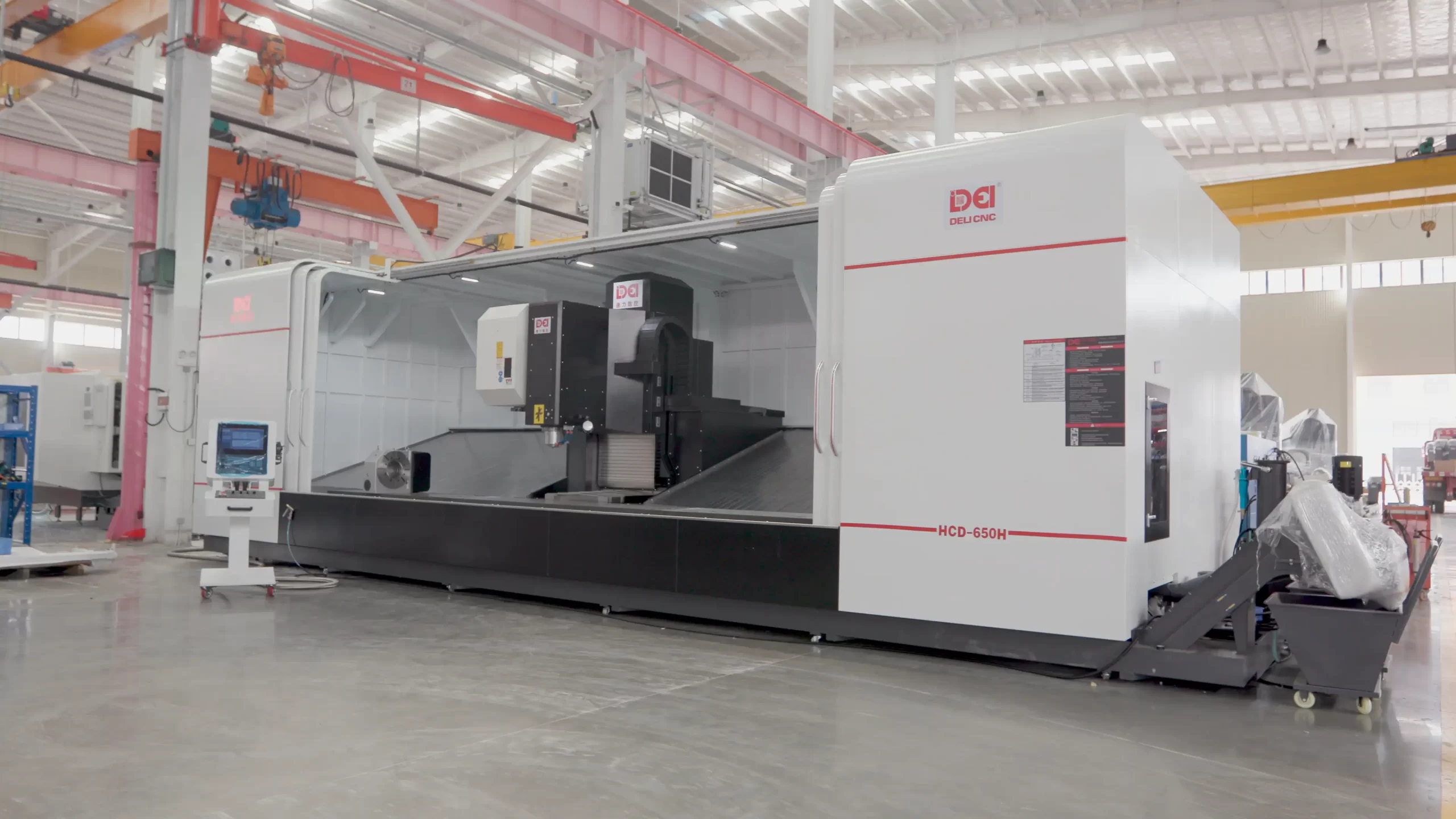 Full view of the Deli CNC HCD-650H large enclosed machining center in an industrial factory, featuring a control panel and heavy-duty design for precision metal processing