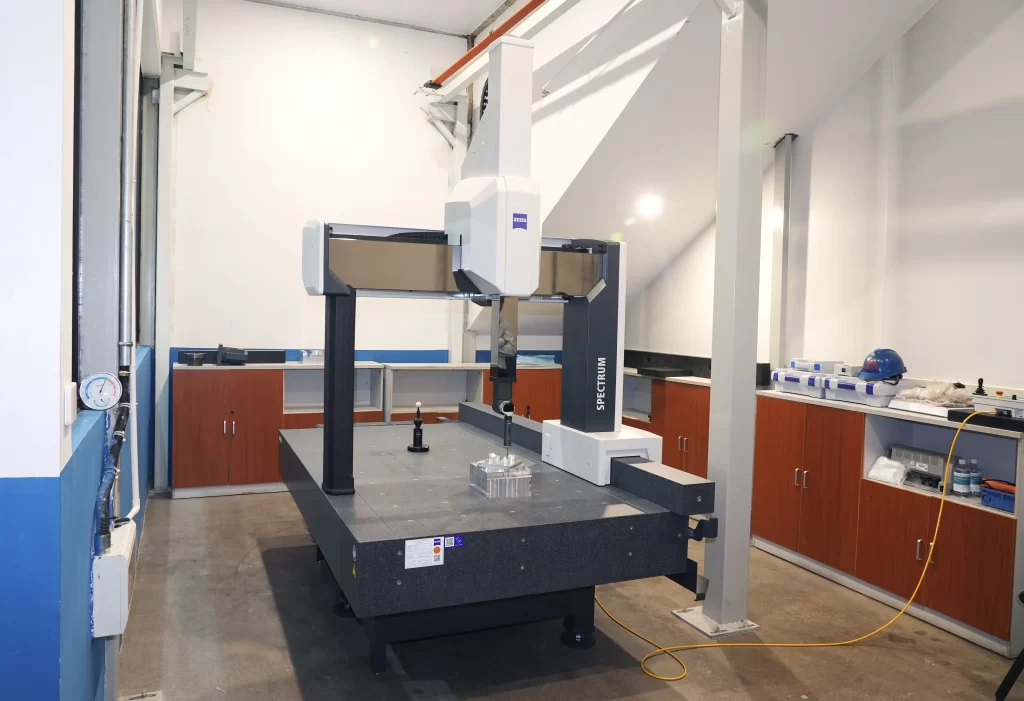 A coordinate measuring machine (CMM) in a lab, verifying part geometry.