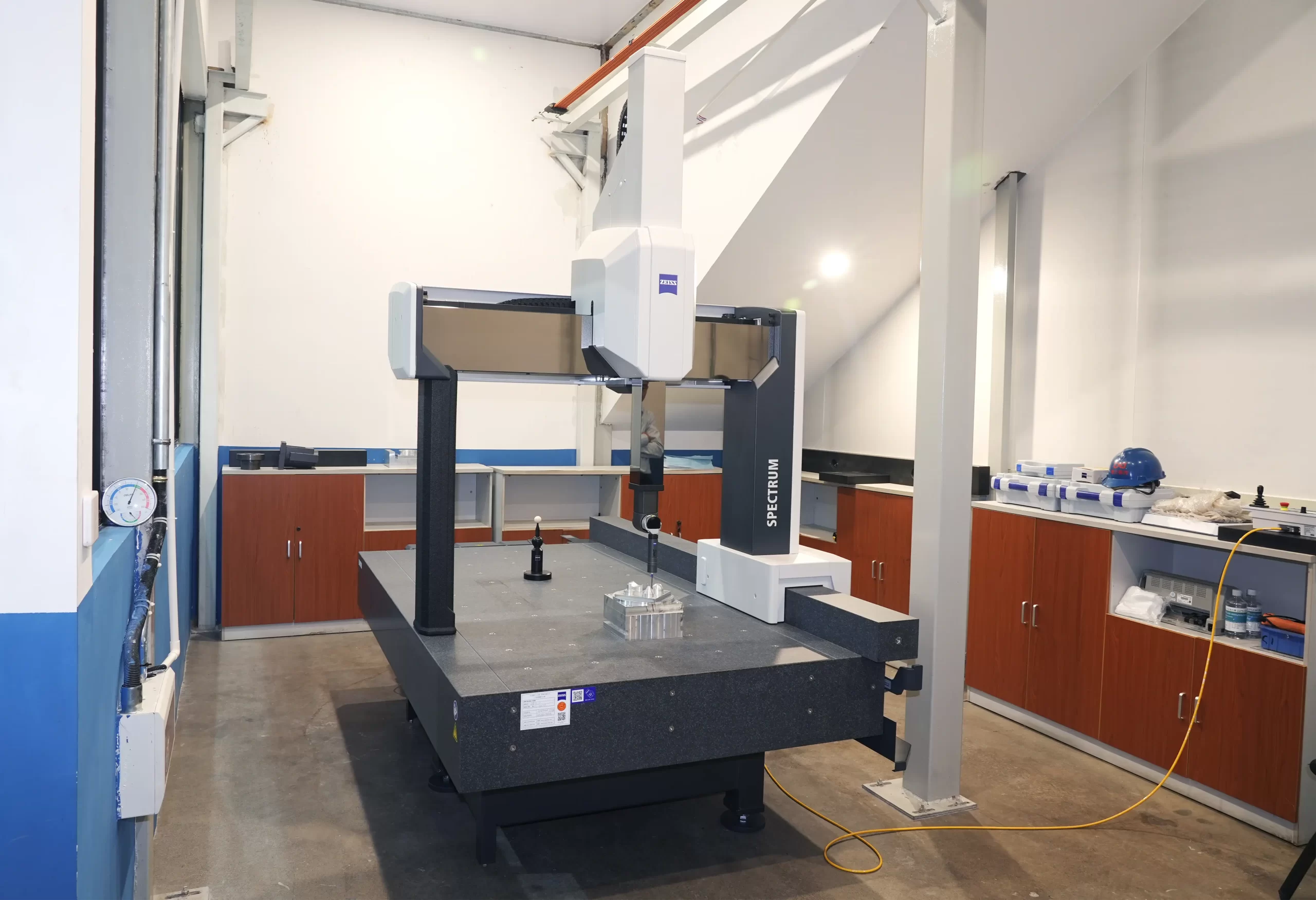 A coordinate measuring machine (CMM) in a lab, verifying part geometry.
