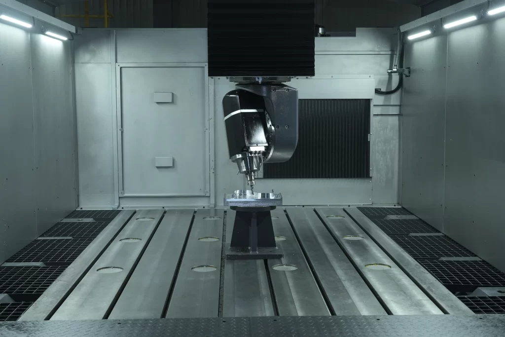 A high-precision 5-axis CNC machining center with the spindle and cutting tool aligned with the workpiece, in the process of machining. It showcases the scene of complex curved surface part processing, demonstrating the advantages of multi-axis linkage machining, applicable to precision manufacturing fields such as aerospace and automotive production.