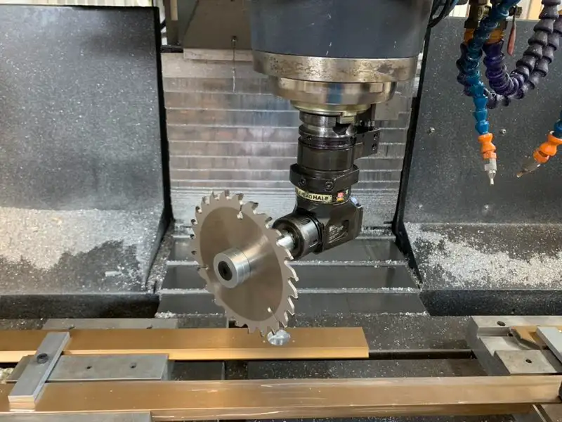 The tool of a CNC milling machine is processing a metal saw blade. The internal structure of the machine tool is clear, and metal chips are faintly visible during the cutting process, reflecting the fine operation of metal processing.
