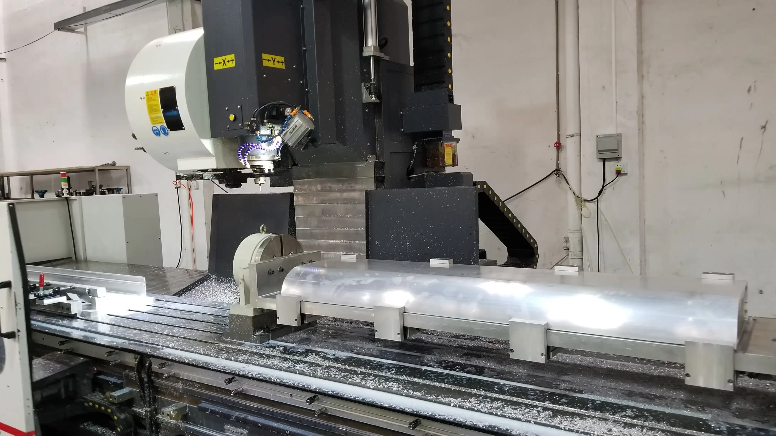 A CNC machine precisely machining an aluminum component, with the workpiece and machining process clearly visible.