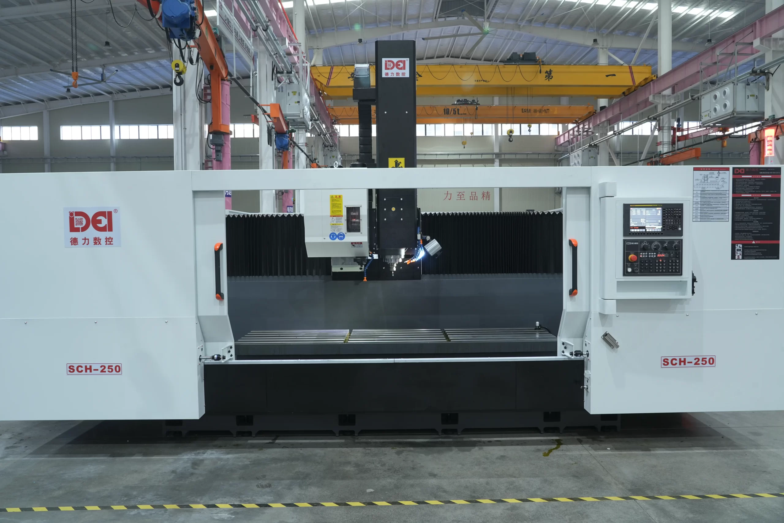 Full view of DELI SCH-250 CNC milling machine in an industrial workshop, with overhead cranes and factory facilities in the background.
