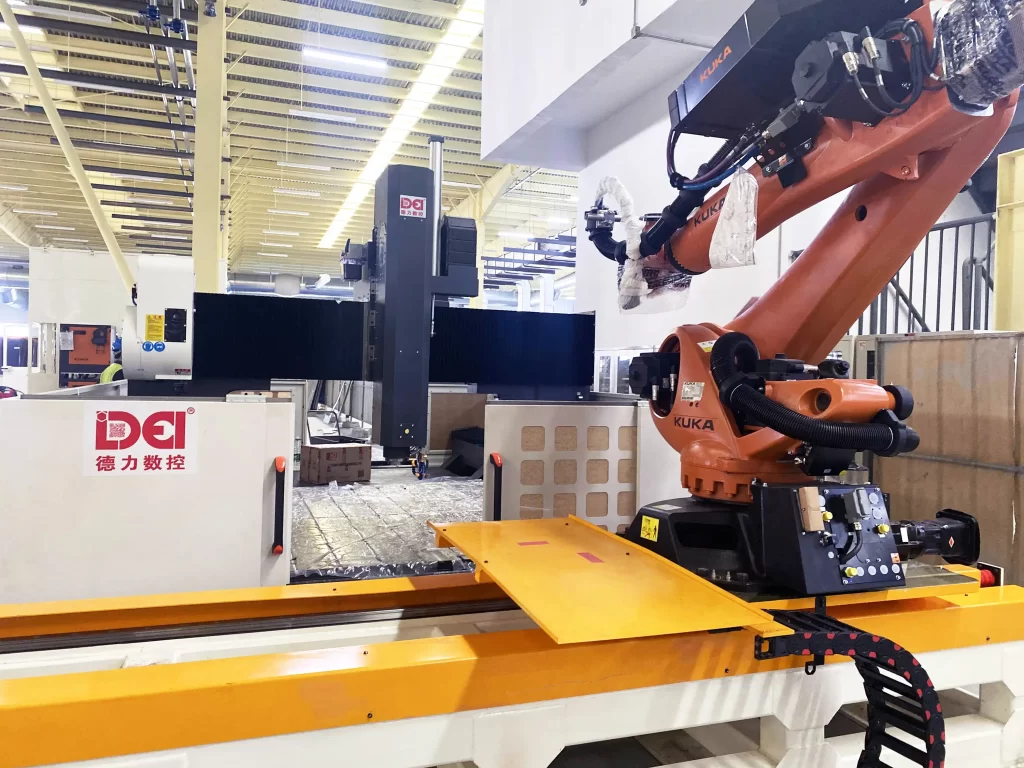 A large industrial CNC machine paired with a robotic arm in a manufacturing facility, showcasing automated machining capabilities.