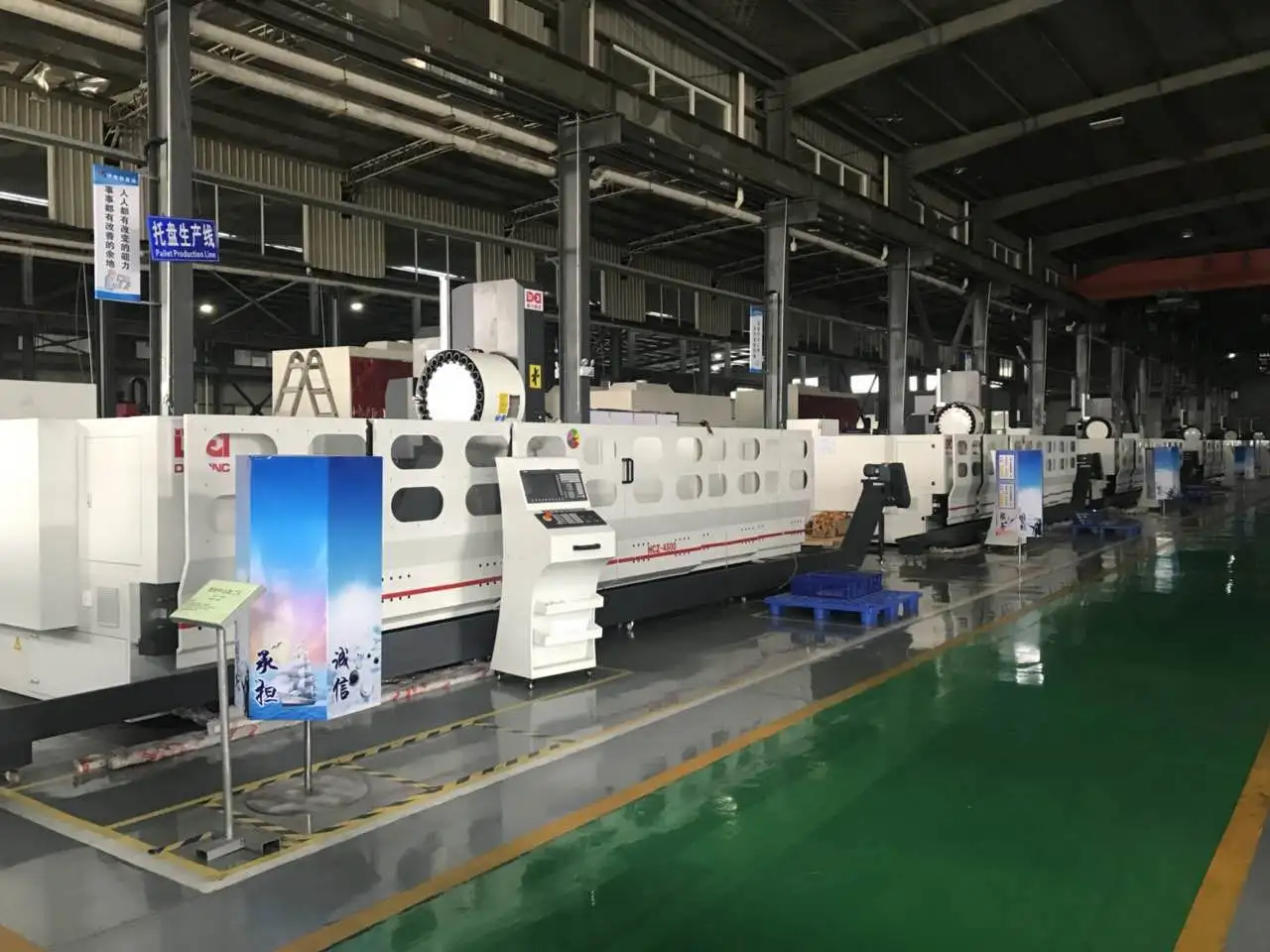 Multiple CNC machining centers are neatly arranged in a smart factory. The floor is clean, and there are production signs, reflecting a modern CNC production scene.