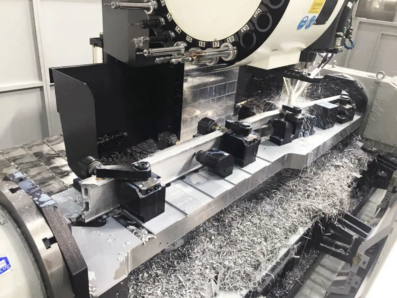 A CNC machining center uses flood coolant to machine aluminum parts, with coolant spraying to remove chips and control heat, showing the integration of the coolant system during cutting.
